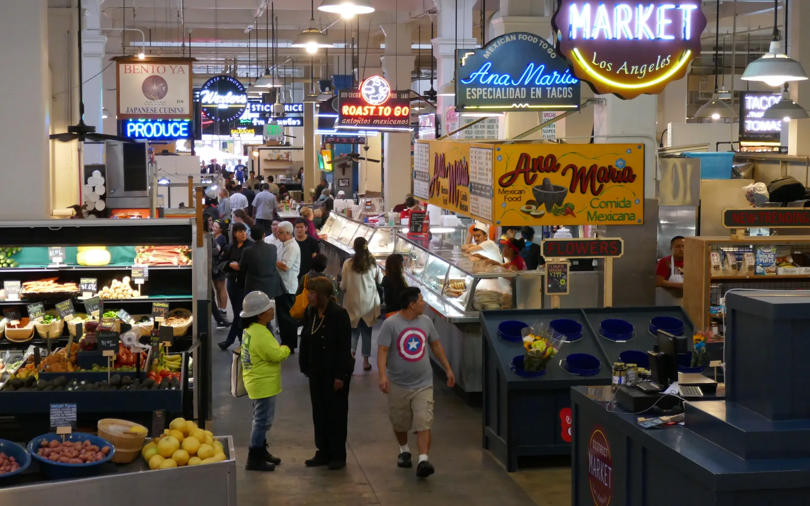 Interior of Grand Central Market in Los Angeles with vendors, shoppers, and market stalls displaying food and goods